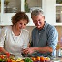 Pareja adulta cocinando juntos alimentos saludables en una cocina moderna