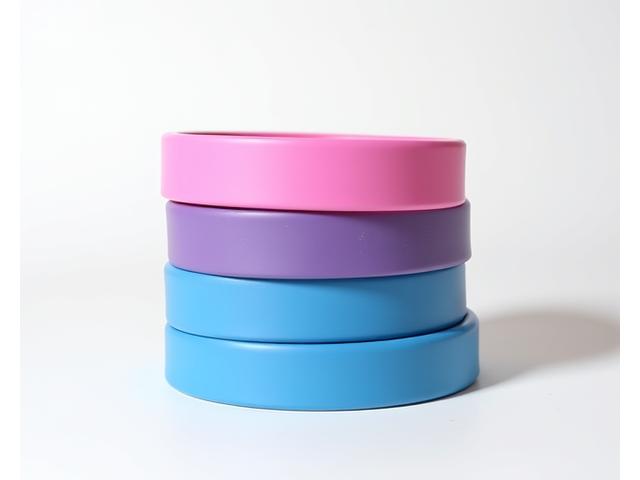 Set de bandas de resistencia de colores vibrantes apiladas, en un gimnasio casero con suelo de madera.